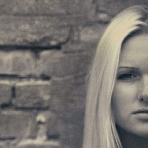Woman looking with a brick wall looking onward