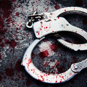 Bloody red handcuffs on a grey texture