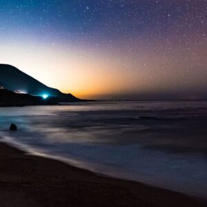 Sunset beach landscape scene with a starry sky